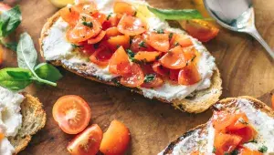 Krajíce chleba s čerstvým sýrem a rajčaty