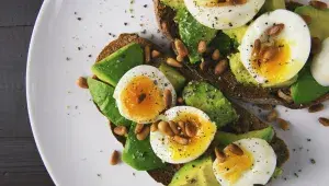 Celozrnný chléb s avokádem, vejcem a piniovými oříšky