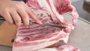 Italská porchetta - porcování masa - odříznutí žeber