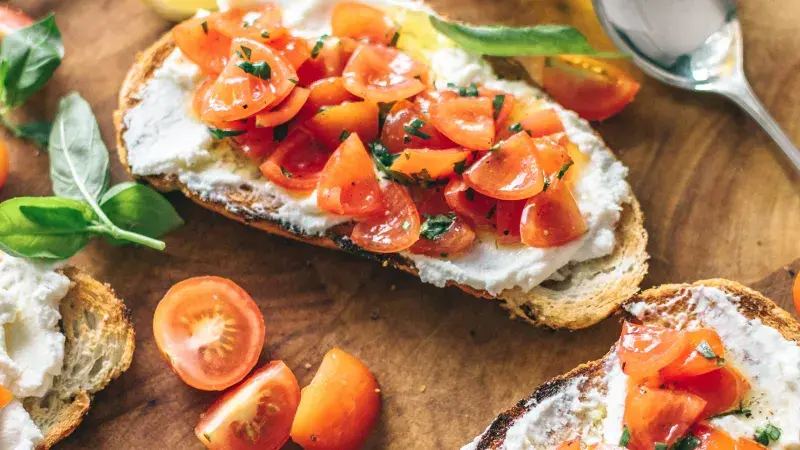 Krajíce chleba s čerstvým sýrem a rajčaty