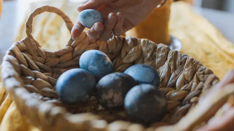 Modrá velikonoční vajíčka v proutěném košíku