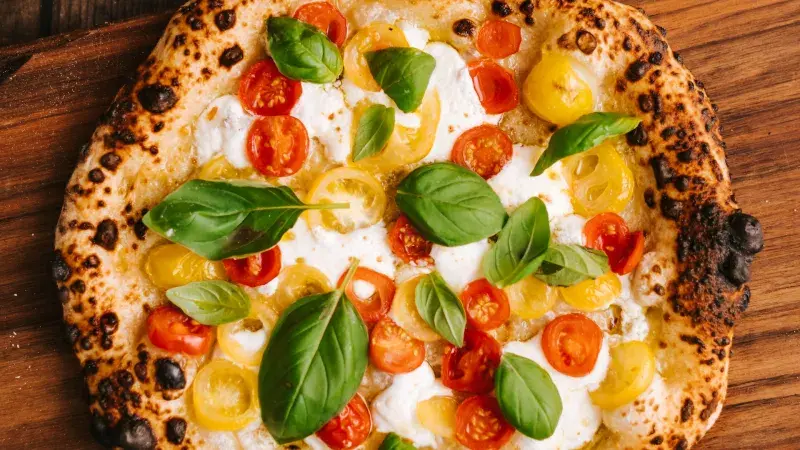 pizza s mozzarellou, rajčaty a čerstvou bazalkou