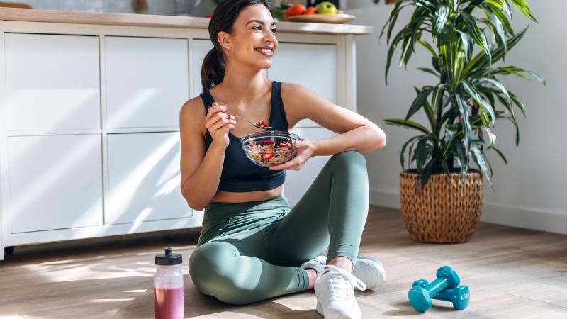 Athletic woman eating a healthy bowl of muesli