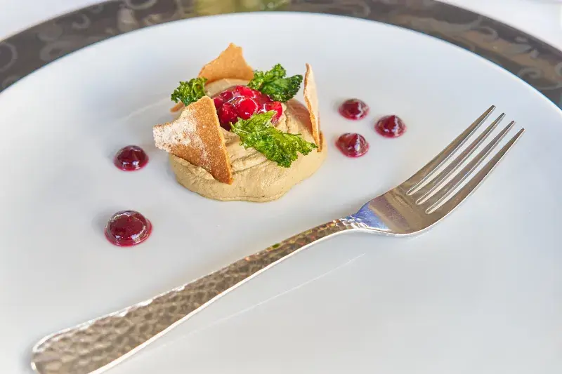 Máslová paštika z kachních jater s kmínovým chipsem, brusinkami s portským vínem a kadeřávkem.