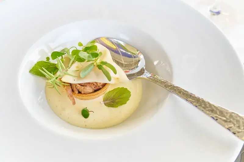 Pohankový košíček plněný teplým hovězím konfitem s marinovaným celerem a bramborovo-lanýžovou espumou.