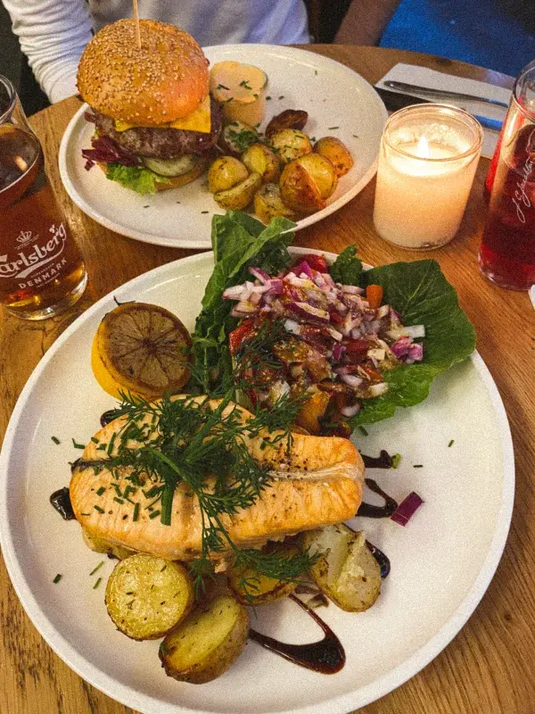 Losos s pečenými brambory a salátem a Paludan’s burger z hovězího masa s čedarem, slaninou, pečenými bramborami a chilli majonézou