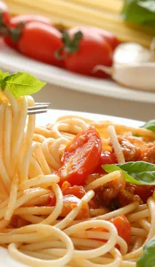 Celozrnné špagety s červenou cibulí, rajčátky a bazalkou